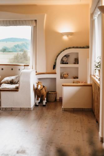 a childs bedroom with a large window and a stuffed animal at Almenlandhof in Fladnitz an der Teichalm
