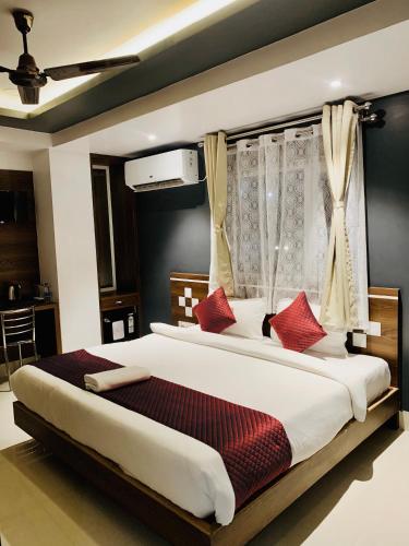 a bedroom with a large bed with red pillows at Shanti Regency in Guwahati