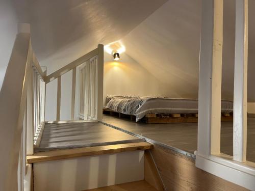 an attic room with a bed and a window at La Maison d’Elise in Beine