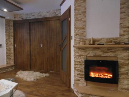 a fireplace in a living room with a brick wall at Apartament U Janusza in Nowy Targ