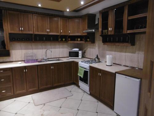 a kitchen with wooden cabinets and a stove top oven at Apartament U Janusza in Nowy Targ