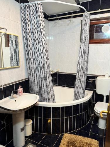 a bathroom with a tub and a sink and a toilet at Laganini Cozy Home in Velika Mlaka