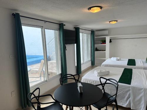 a bedroom with a bed and a table and chairs at Casa Dorada in Cancún