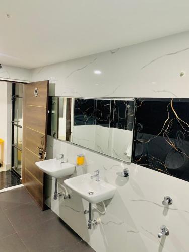 a bathroom with two sinks and a mirror at Shanti Regency in Guwahati