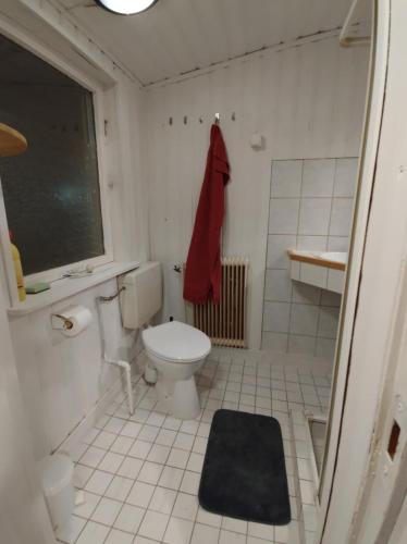 a bathroom with a toilet and a red towel at Älgklinten with type 2 charger in Brograngen
