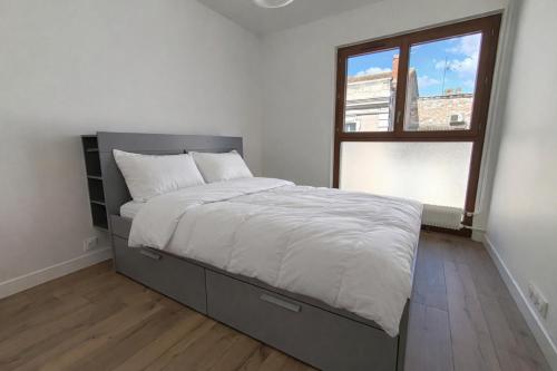a bedroom with a large bed with a window at Les toits du Lot in Villeneuve-sur-Lot