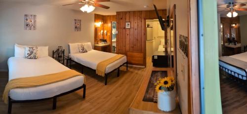 a hotel room with two beds and a bathroom at Trees Motel in Bishop
