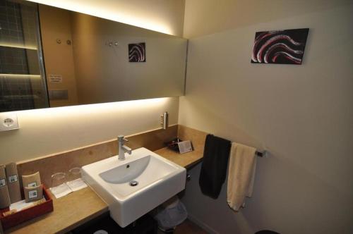 a bathroom with a sink and a mirror at Resataurant and Rooms Cabrit in Sant Mateu