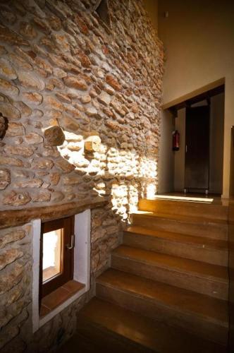a stone building with stairs and a stone wall at Resataurant and Rooms Cabrit in Sant Mateu