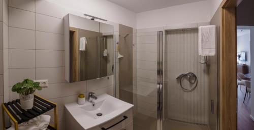 a bathroom with a sink and a shower at Alma Suites Győr in Győr