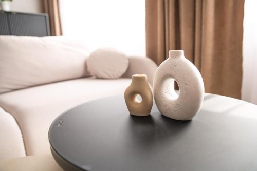 two vases sitting on a table in a living room at Alma Suites Győr in Győr