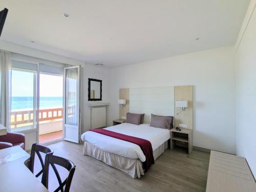 ein Hotelzimmer mit Bett und Meerblick in der Unterkunft Hotel Uhainak in Hendaye