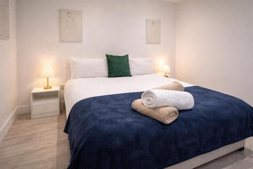 a bedroom with a large bed with towels on it at La Rose Serenity Residence Elegant Rooms in London