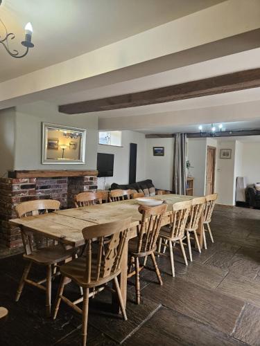 a large wooden table and chairs in a room at The Holmes Barn - Sleeps 16 - Pet friendly in Buxton