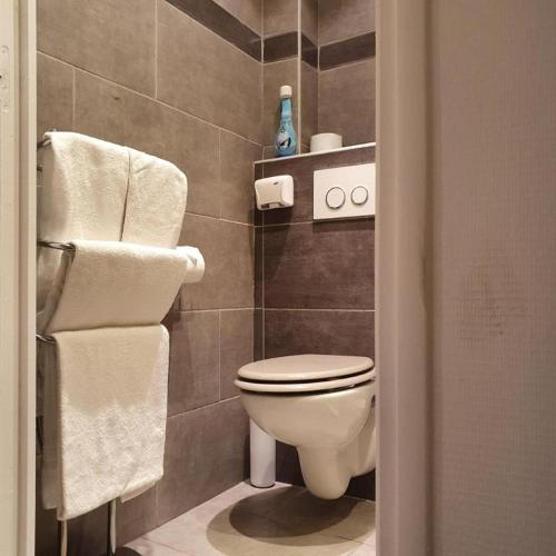 a bathroom with a toilet and towels at Le Petit Château - Cannes in Cannes