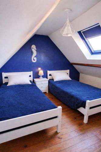 two beds in a attic bedroom with blue walls at Les Champs d'Opale in Bréxent-Énocq