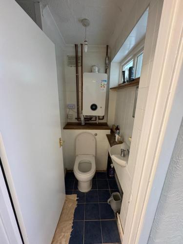 a small bathroom with a toilet and a sink at Amirs house in Hackington