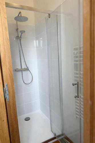 a shower with a glass door in a bathroom at La Loge Appartement 1 in Beauquesne