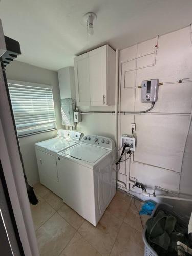 a small kitchen with a washing machine and cabinets at 1008 Gardens in Vero Beach