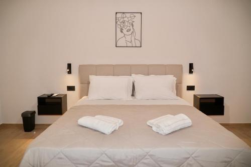 a bedroom with a large bed with two white towels at BellaDiAnna Apartment in Symi