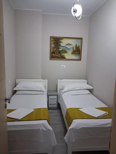 three beds in a room with a picture on the wall at holiday house in Durrës