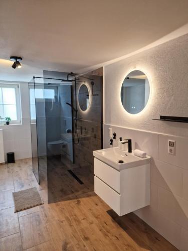 a bathroom with a white sink and a shower at Old City Apartment Möckmühl in Möckmühl