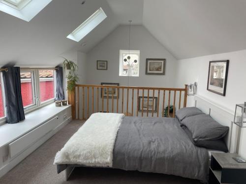 a bedroom with a bed in a room with windows at Yew Trees Barn in Backwell