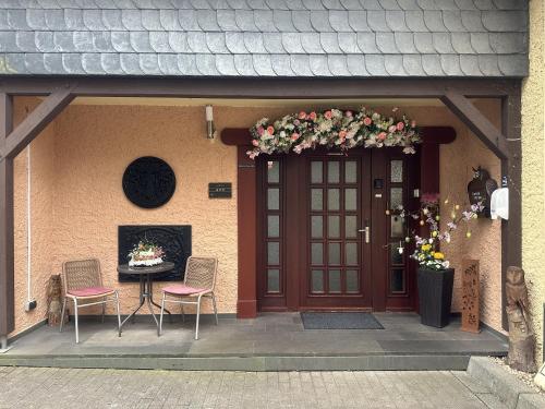 a front door of a house with a table and chairs at Hotel Eulenhof in Gransdorf