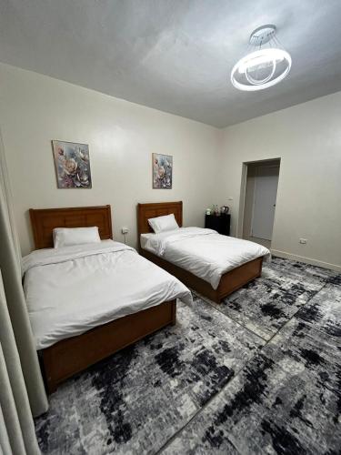 a bedroom with two beds and a chandelier at Terra Pyramids Hotel in Cairo