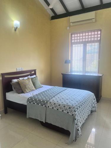 a bedroom with a bed and a window at Airport home stay in Ekala