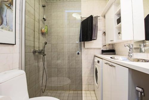 a bathroom with a shower and a toilet and a sink at Apartment Savonkatu 25 in Kuopio