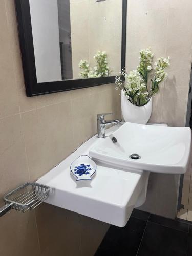 a bathroom sink with a mirror and a bowl on it at Airport home stay in Ekala
