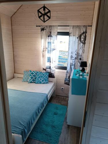 a small bedroom with a bed and a window at Domki Pod Świerkami in Jezierzany