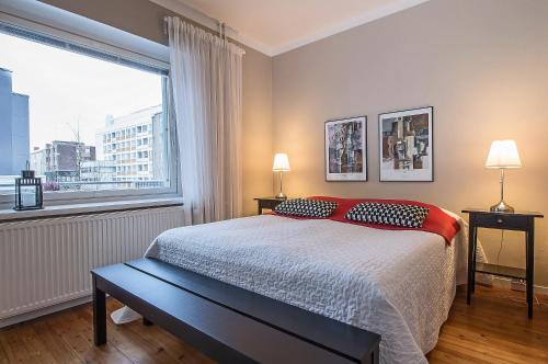 een slaapkamer met een bed en een groot raam bij Apartment Savonkatu 25 in Kuopio