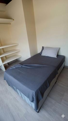 a bedroom with a large bed with a blue blanket at Apartamento Paraiso Nuquí in Nuquí