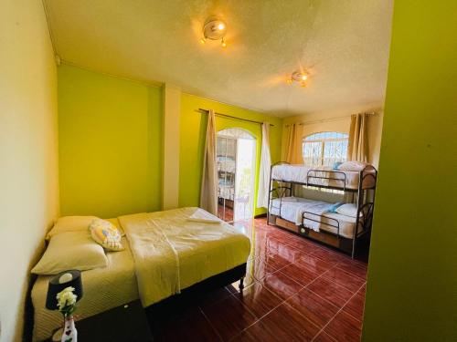 a bedroom with two beds in a room with green walls at Amazon Jade Hotel Boutique in San Bartolomé Milpas Altas