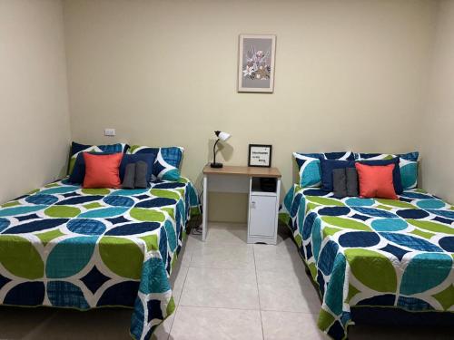 a bedroom with two beds with blue and green at Room #2 donde Alice in San Miguel