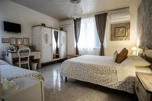 a bedroom with two beds and a table and a window at Grotta dei Puntali B&B in Carini