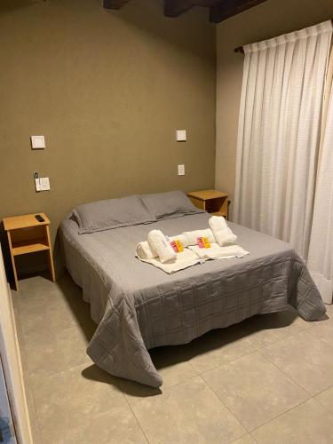 a bedroom with a bed with towels on it at El Atardecer Complejo Turístico in San Rafael