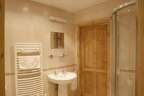 a white bathroom with a sink and a shower at The Holmes Barn - Sleeps 16 - Pet friendly in Buxton