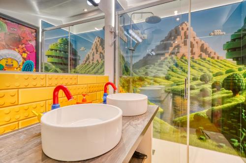 two sinks in a bathroom with a mountain mural at BRICKIMMERSION Suite Luxe - Cinéma Privé climatisé - Billard - Secret Room - 10min Fontainebleau - 25min Paris Ligne R in Melun