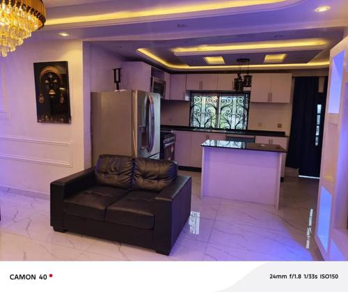 a living room with a couch and a kitchen at Ngalle guest house in Buea