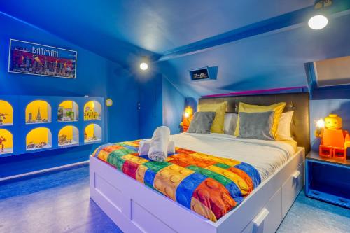 a bedroom with a bed in a blue room at BRICKIMMERSION Suite Luxe - Cinéma Privé climatisé - Billard - Secret Room - 10min Fontainebleau - 25min Paris Ligne R in Melun