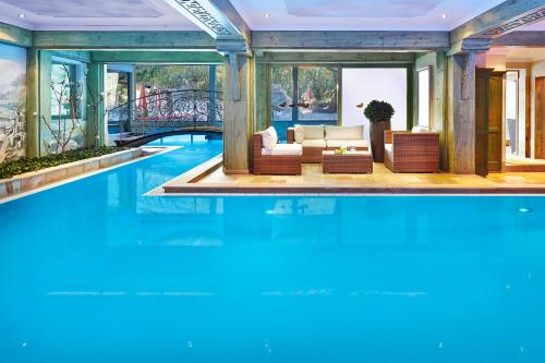 a villa with a swimming pool and a living room at Relais&Châteaux Spa-Hotel Jagdhof in Neustift im Stubaital