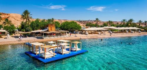 a beach with chairs and tables in the water at וילת האושר אילת in Eilat