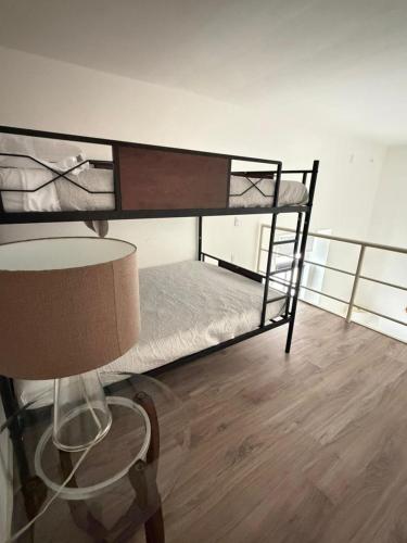 two bunk beds in a room with a lamp and a table at Casa Alhaja - Diamante in Guadalajara