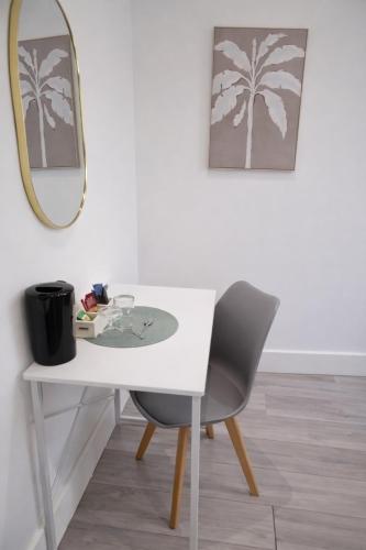 a white table with a chair and a mirror at La Rose Serenity Residence Elegant Rooms in London