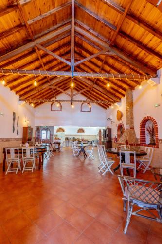 a large room with wooden ceilings and tables and chairs at Cangalho Village House Premium in Azueira