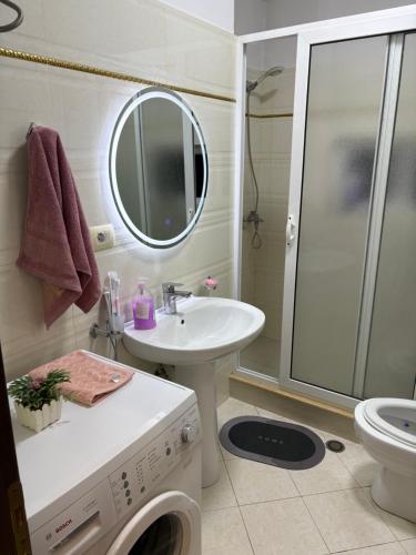 a bathroom with a washing machine and a sink at Shtepi ditore elbasan in Elbasan