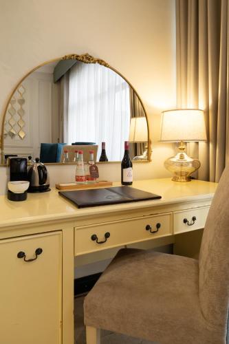 a desk with a sink and a mirror at Villa Monticello Boutique Hotel in Accra